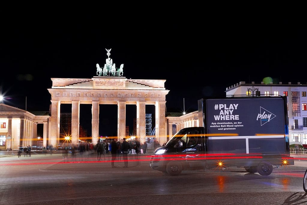 Nachtaufnahme einer mobilen 18/1-Großfläche auf einem Kleintransporter vor dem Brandenburger Tor