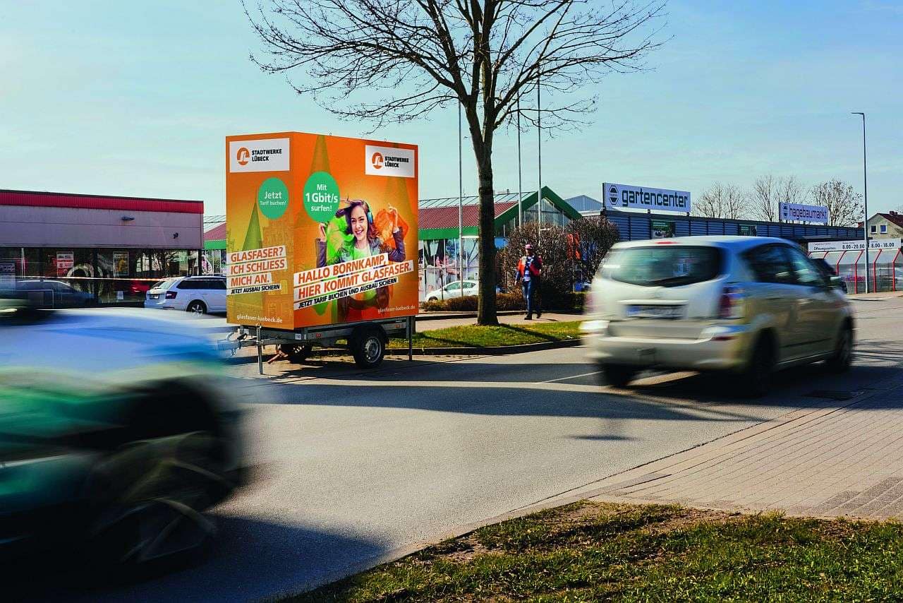 Foto eines am Straßenrand geparkten Werbeanhängers Foto eines am Straßenrand geparkten Werbeanhängers