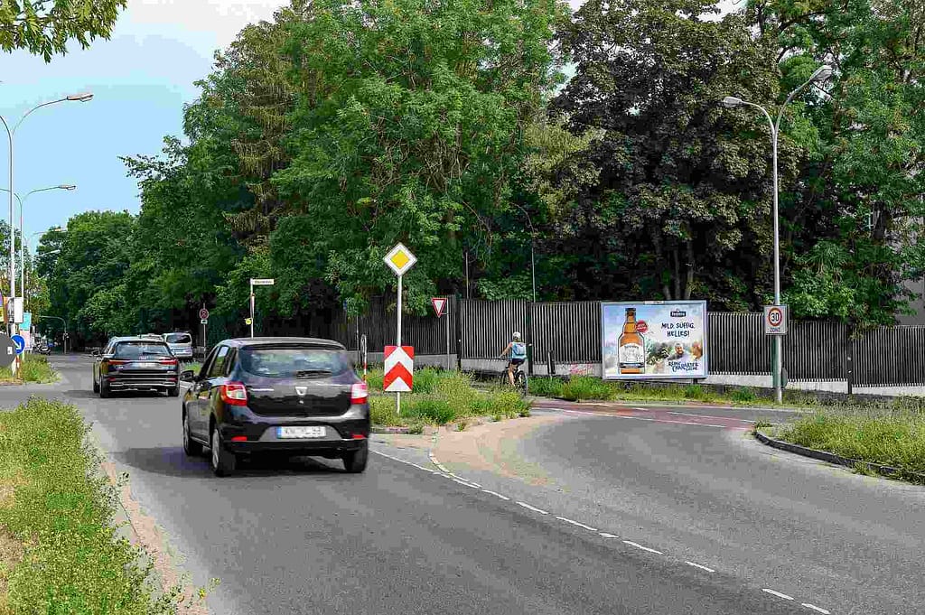 Foto einer Großfläche an einem Zaun quer zur Straße positioniert Foto einer Großfläche an einem Zaun quer zur Straße positioniert