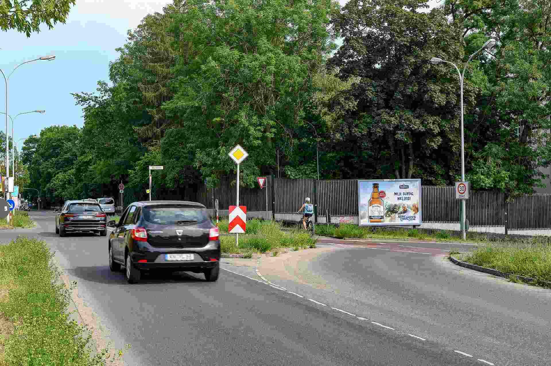 Foto einer Großfläche an einem Zaun quer zur Straße positioniert
