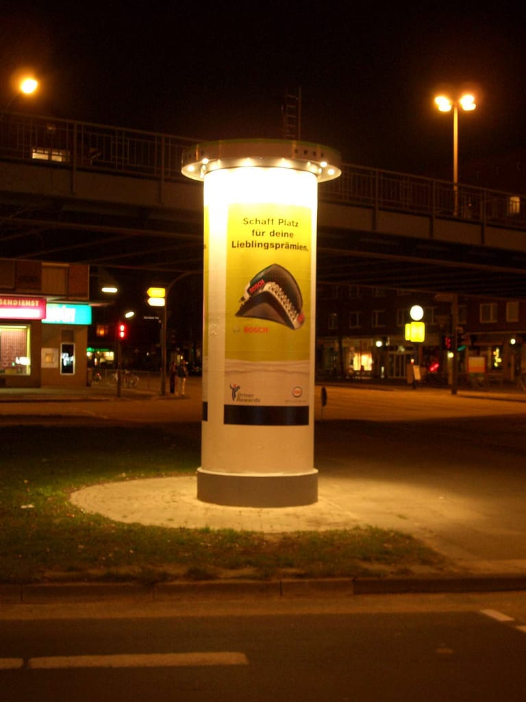 Nachtaufnahme einer beleuchteten Ganzsäule