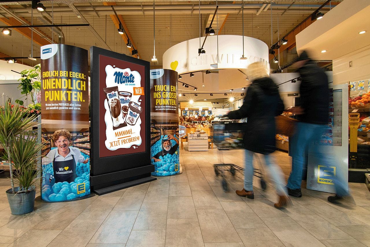 Digitales CityLightPoster neben weiteren Werbeaufstellern im Zugangsbereich eines Edeka-Marktes Digitales CityLightPoster neben weiteren Werbeaufstellern im Zugangsbereich eines Edeka-Marktes