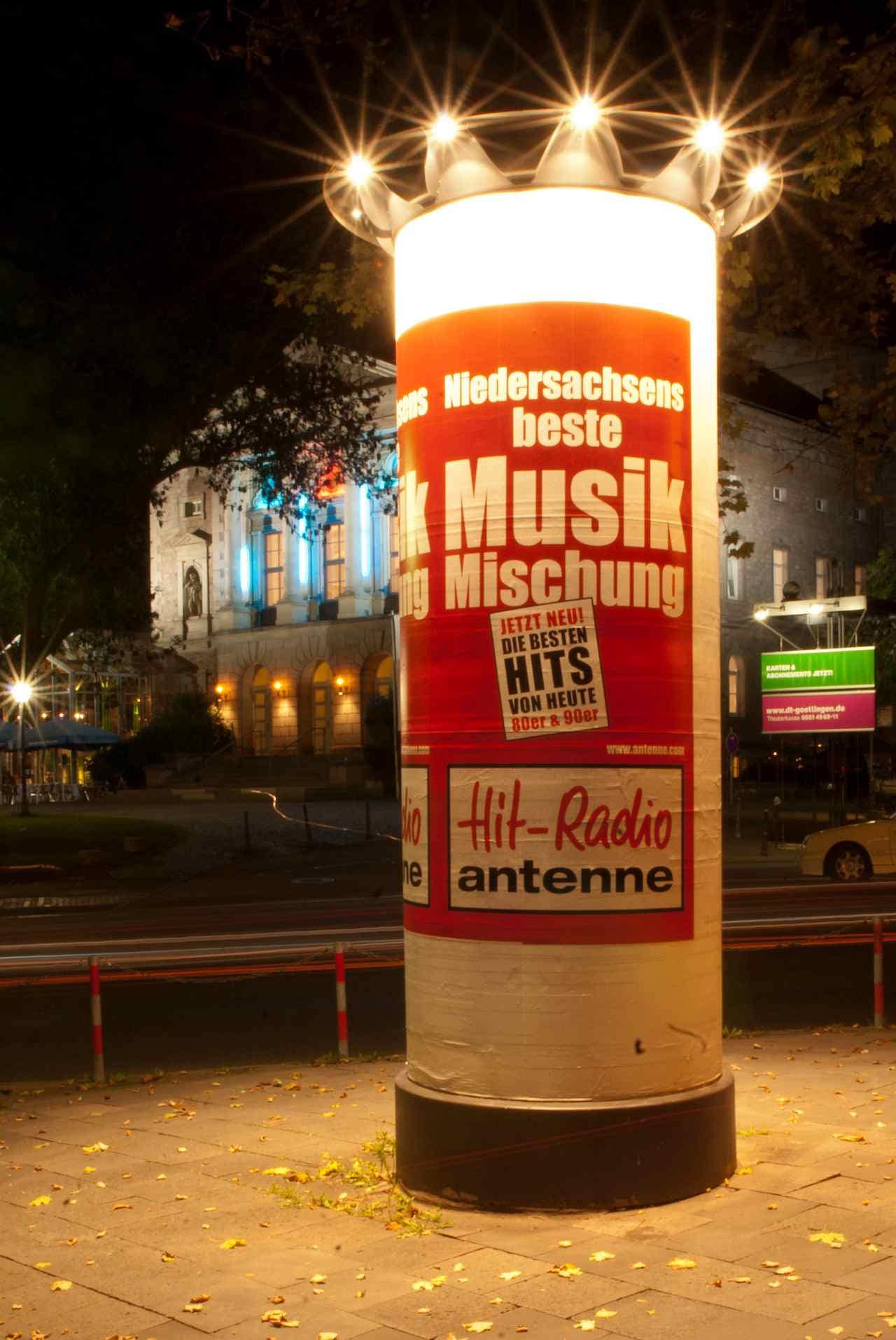 Nachtaufnahme einer beleuchteten Ganzsäule mit 6/1-Bogen-Plakatierung Nachtaufnahme einer beleuchteten Ganzsäule mit 6/1-Bogen-Plakatierung